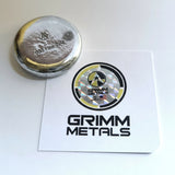 hand poured polished zinc round and paper with 'Grimm Metals' logo on a white background