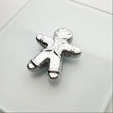 Silver gingerbread man charm on a light gray background
