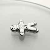 Silver gingerbread man charm on a light gray background