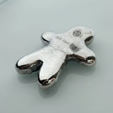 Silver gingerbread man charm on a light gray background