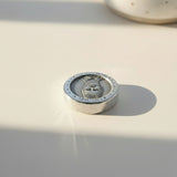 zinc round with engraved design on a clean background