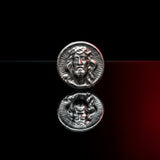 Silver coin with a face design on a gray background