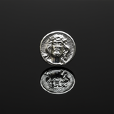 polished zinc button with a face design on a light gray background