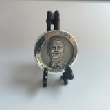 polished Zinc round with a portrait on a black stand against a white background